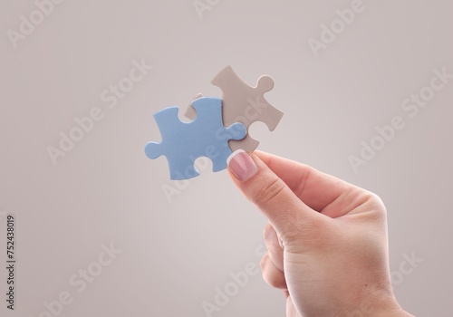 People hands connecting colored puzzles.