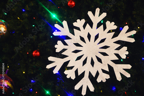 Beautiful large white decorative snowflake on a dark background. Evening festive Christmas illumination.