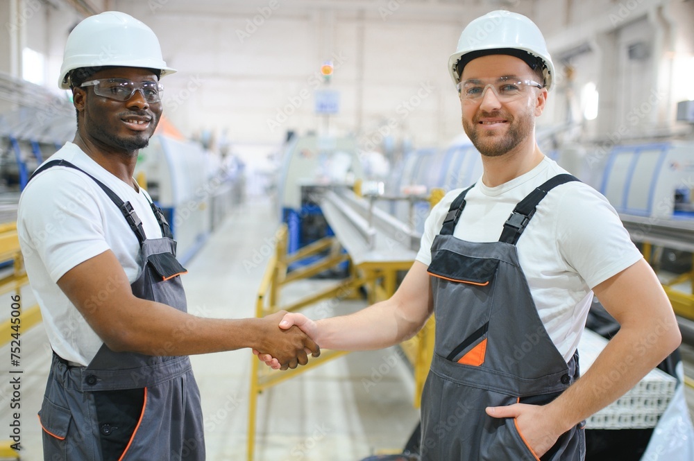 Obraz premium Two Heavy Industry Engineers Stand in Factory