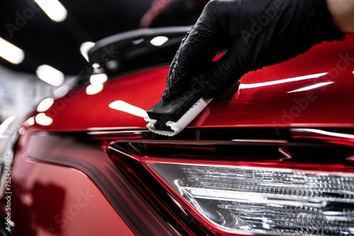 Obraz na płótnie Car detailing or car wash worked applying ceramic coating on red car body w salonie