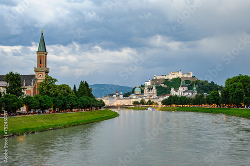 Majestic view of hohensalzburg fortress overlooking salzach river at dusk during stormy weather