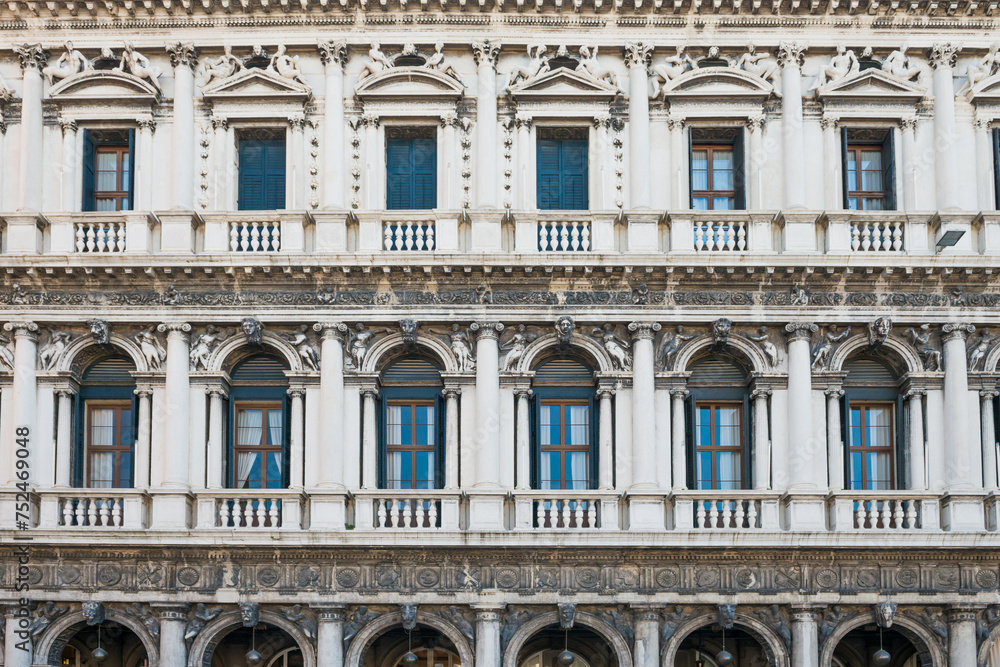 Marble arcades at facade of historical building at San Marco square in Venice, Italy