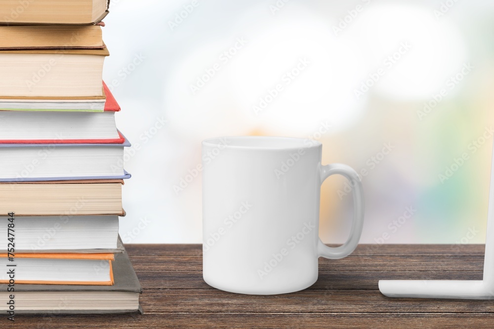 White ceramic cup and notebooks on table White ceramic cup and notebooks on table