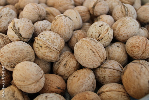 shelled walnuts. Pile of unshelled walnuts in daylight. walnut background.