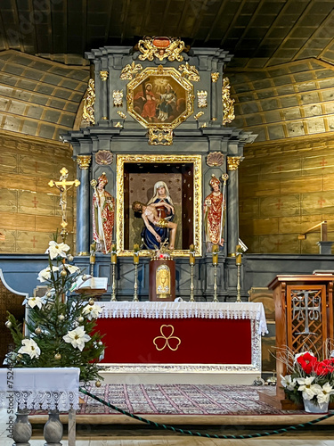 Koszecin, Poland, January 4, 2024: Interior of the old wooden church of the Holy Trinity in Koszecin, Poland. Main altar with pieta photo