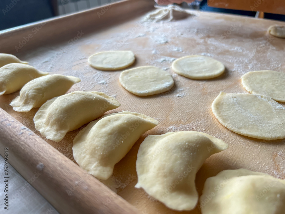Home-made dumplings, kneading the dough by hand, rolling it, cutting it out and gluing it together Home-made dumplings, kneading the dough by hand, rolling it, cutting it out and gluing it together