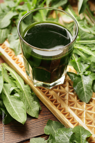 Dandelion juice in a glass with fresh leaves as a salad on wooden rustic table, natural healthy drinks concept