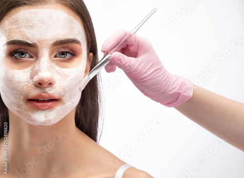 Beautician makes a face mask to rejuvenate the skin. Cosmetology treatment of problem skin on the face and body.