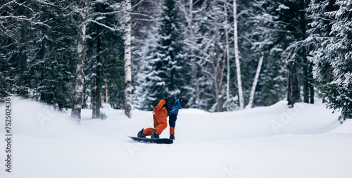 Freeride snowboarding in Sheregesh Ski Resort on background snowy forest. Man snowboarder rides through snow, explosion photo