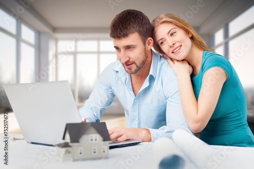 Happy young couple with computer laptop at home