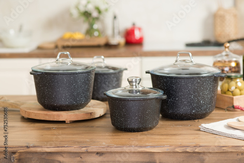 A set of pots for cooking stands in a bright kitchen