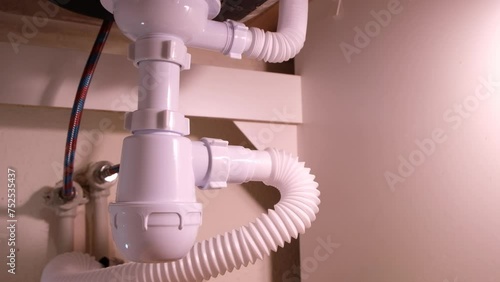 Repairing plumbing pipes under the kitchen sink