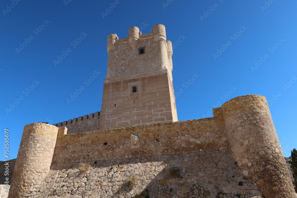 Villena, Alicante, Spain, March 6, 2024: Tower and stone defensive wall of the medieval castle of Arab origin of Atalaya. Villena, Alicante, Spain