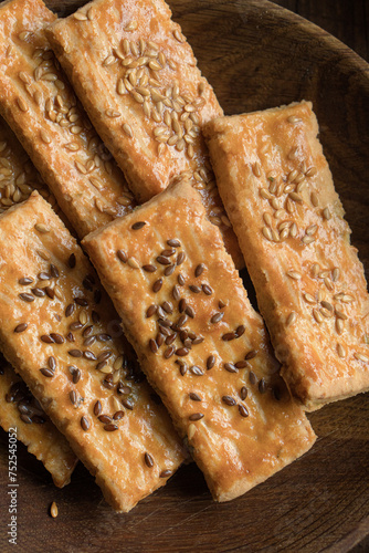 Cookies in the form of a rectangle with sesame seeds on a wooden plate