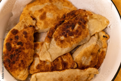 Freshly cooked homemade Fried Chebureks with meat in a bowl. Traditional food.