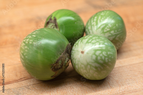 Thai Eggplants on wooden chopping cutting board.