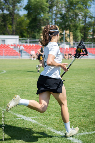 Lacrosse competition - Women's lacrosse player running, holding a lacrosse stick.