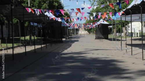 Festival de folklore  en la Pampa Sudamericana de Argentina, decoración en su entrada con banderines en forma de guirnaldas, preparación de los stand para los artesanos y suaves sombras en el suelo  photo