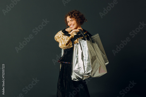 Portrait of a young adult woman dressed in a medieval dress holding shopping bags in hands