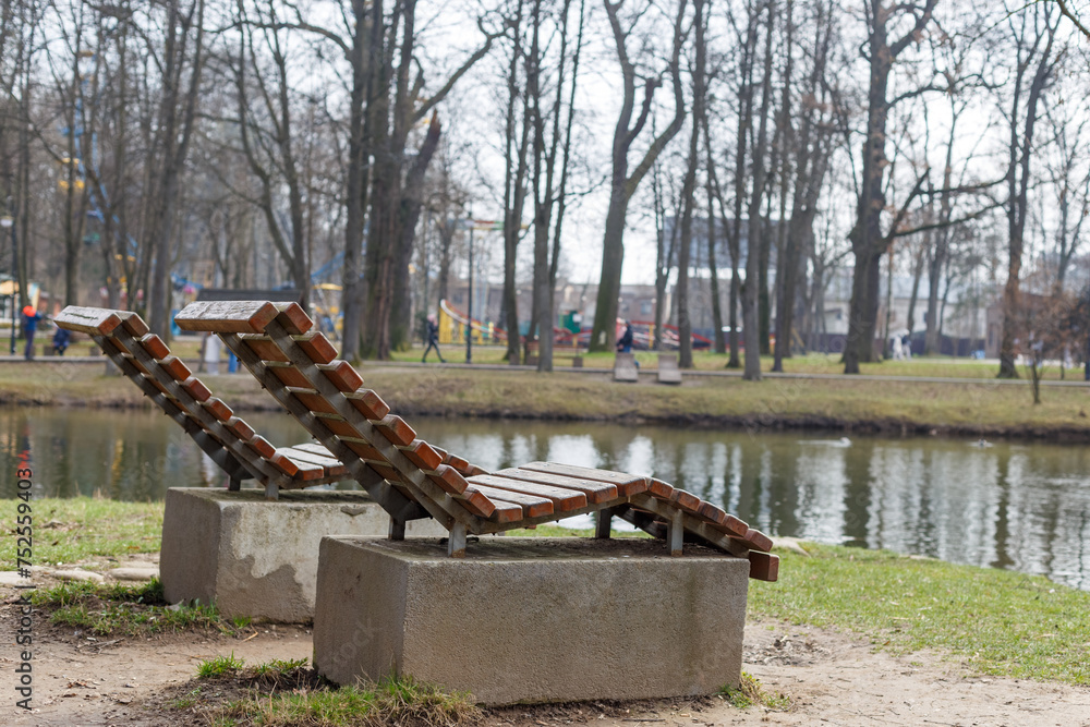 Two deck chairs overlooking a park near the lake.