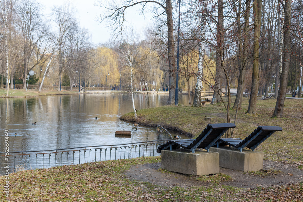 Two deck chairs overlooking a park near the lake.