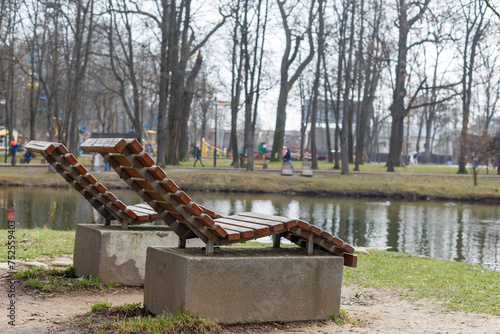 Obraz na płótnie Two deck chairs overlooking a park near the lake. w salonie