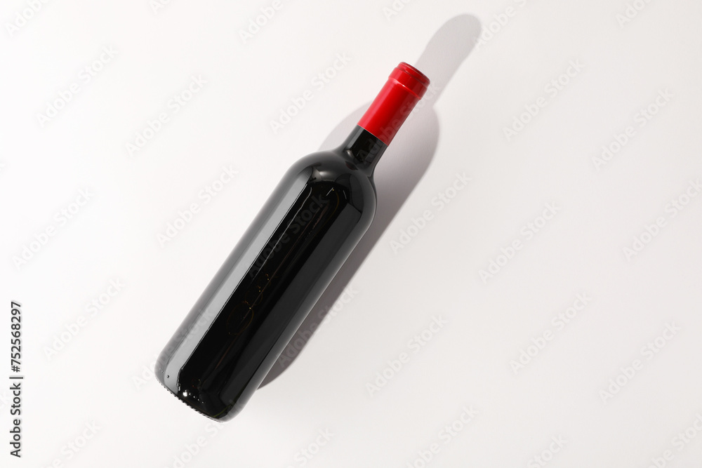Bottle of expensive red wine on white background, top view. Space for text Bottle of expensive red wine on white background, top view. Space for text