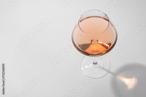 Tasty rose wine in glass isolated on white