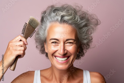 A woman holding a comb and smiling at the camera. Suitable for beauty and hair care concepts