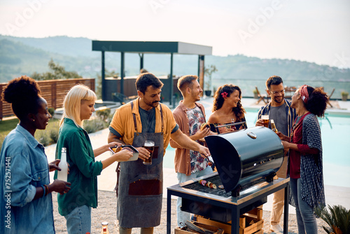 Multiracial group of friends gathering for BBQ party by pool. © Drazen