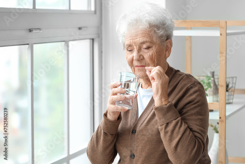 Senior woman taking pill wi...