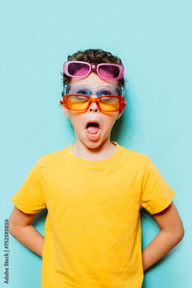 Young boy amazed wearing multiple sunglasses Young boy amazed wearing multiple sunglasses