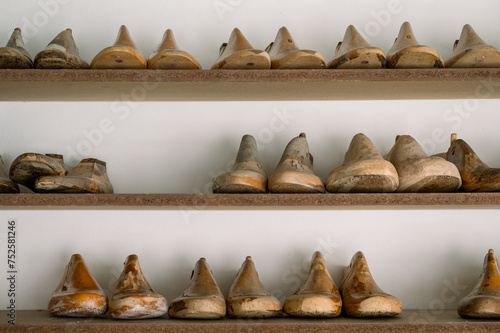 Vintage shoemaking lasts on wooden shelves in Austria photo