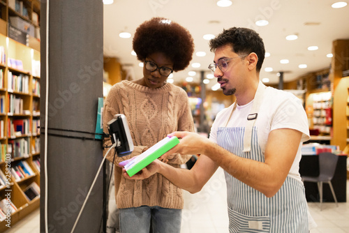 Two people scanning a book in a bookstore photo