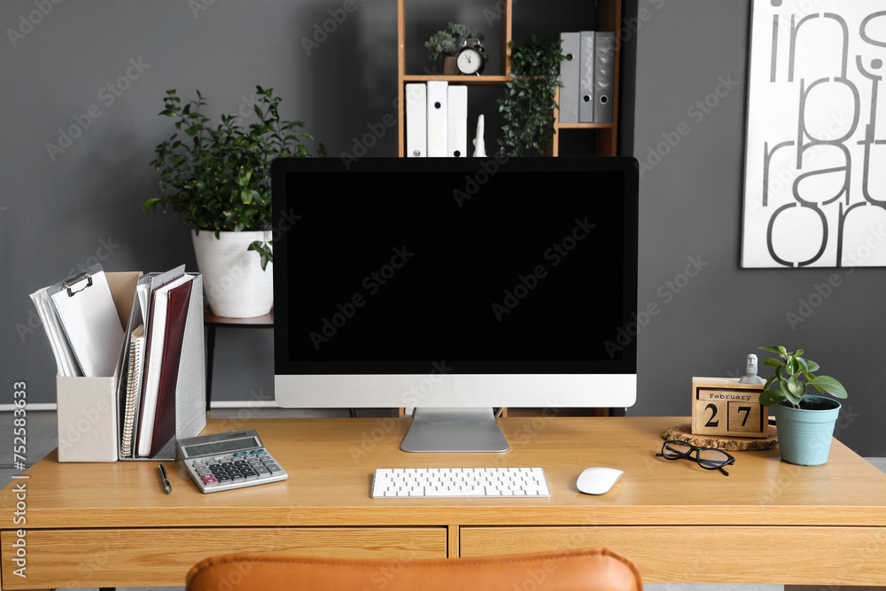 Fototapeta premium Blank computer monitor with documents on table in office