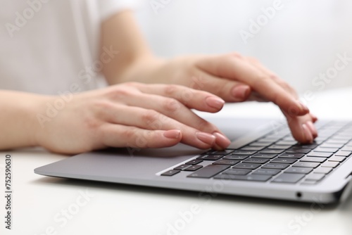 E-learning. Woman using laptop at white table indoors, closeup