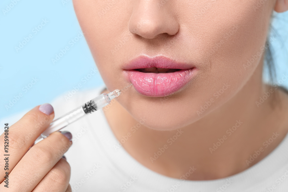 Beautiful young woman holding syringe with filler on color background, closeup Beautiful young woman holding syringe with filler on color background, closeup