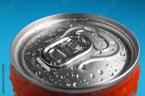Energy drink in wet can on light blue background, closeup