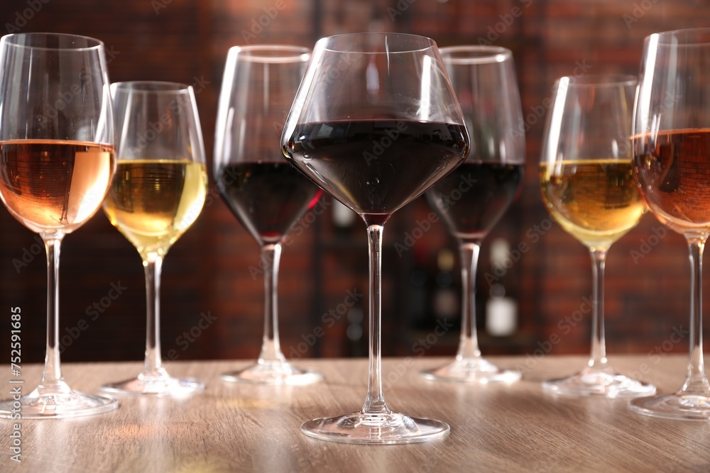 Different tasty wines in glasses on wooden table Different tasty wines in glasses on wooden table