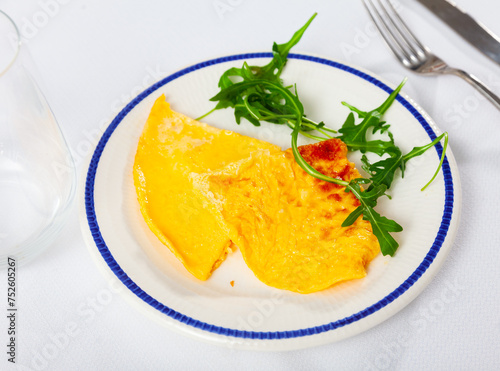 Delicious omelette with arugula served on platter for breakfast