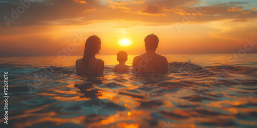 Happy family on the beach at sunset. Mother, father and their little daughter having fun on the ocean.