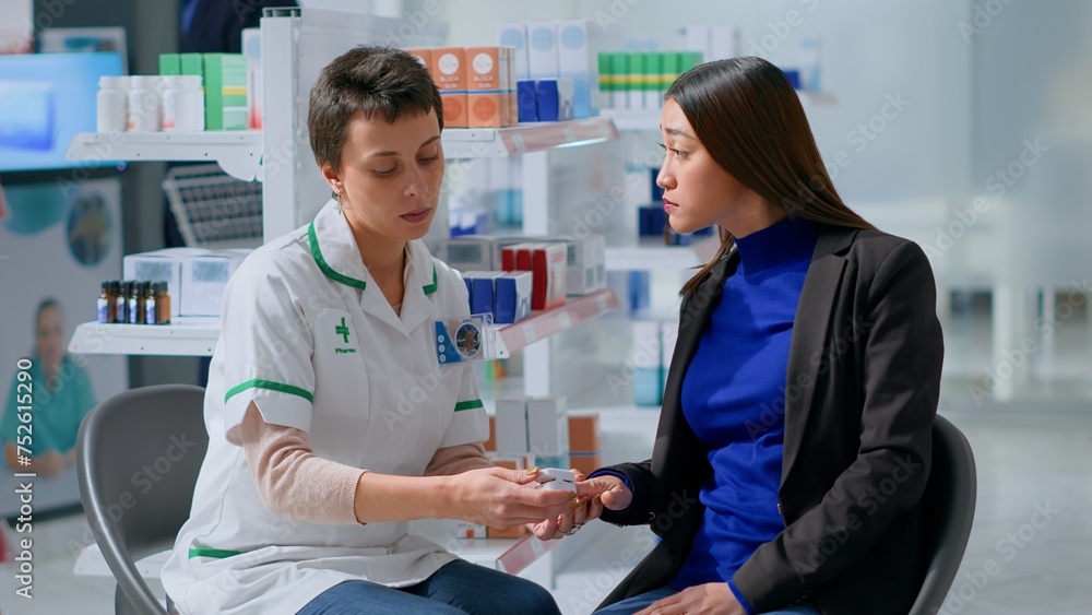 Obraz premium Healthcare expert clipping asian patient finger using pulse oximeter, monitoring level of blood oxygen saturation and heart rate during appointment in chemist shop offering full range of services