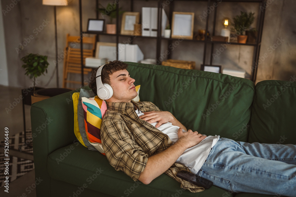 Fototapeta premium One teen man doing guided meditation yoga self care practice at home