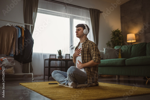 One teen man doing guided meditation yoga self care practice at home