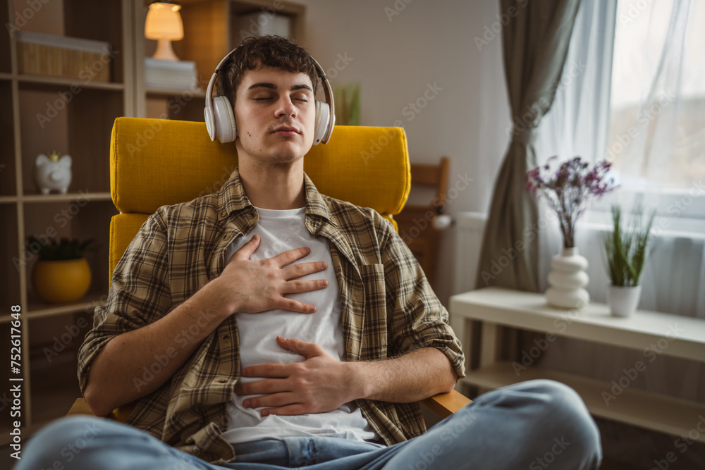 Fototapeta premium One teen man doing guided meditation yoga self care practice at home