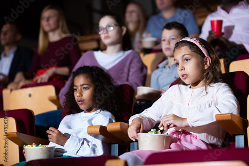 little female viewer sitting at premiere in cinema photo