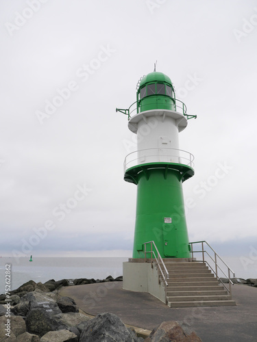 Gr  n-wei   gestreifter Leuchtturm an der Backbord Mole des Hafens Warnem  nde vor der Ostsee