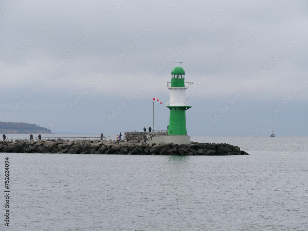 Grün-weiß gestreifter Leuchtturm an der Backbord Mole des Hafens Warnemünde vor der Ostsee