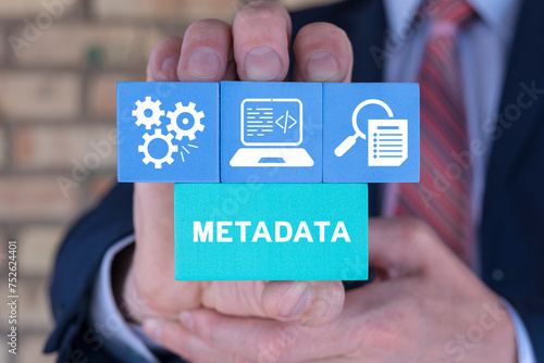 Foto Businessman holding styrofoam blocks sees word: METADATA