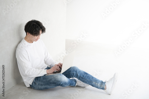 фотографія A young man sitting cross-legged operating a computer